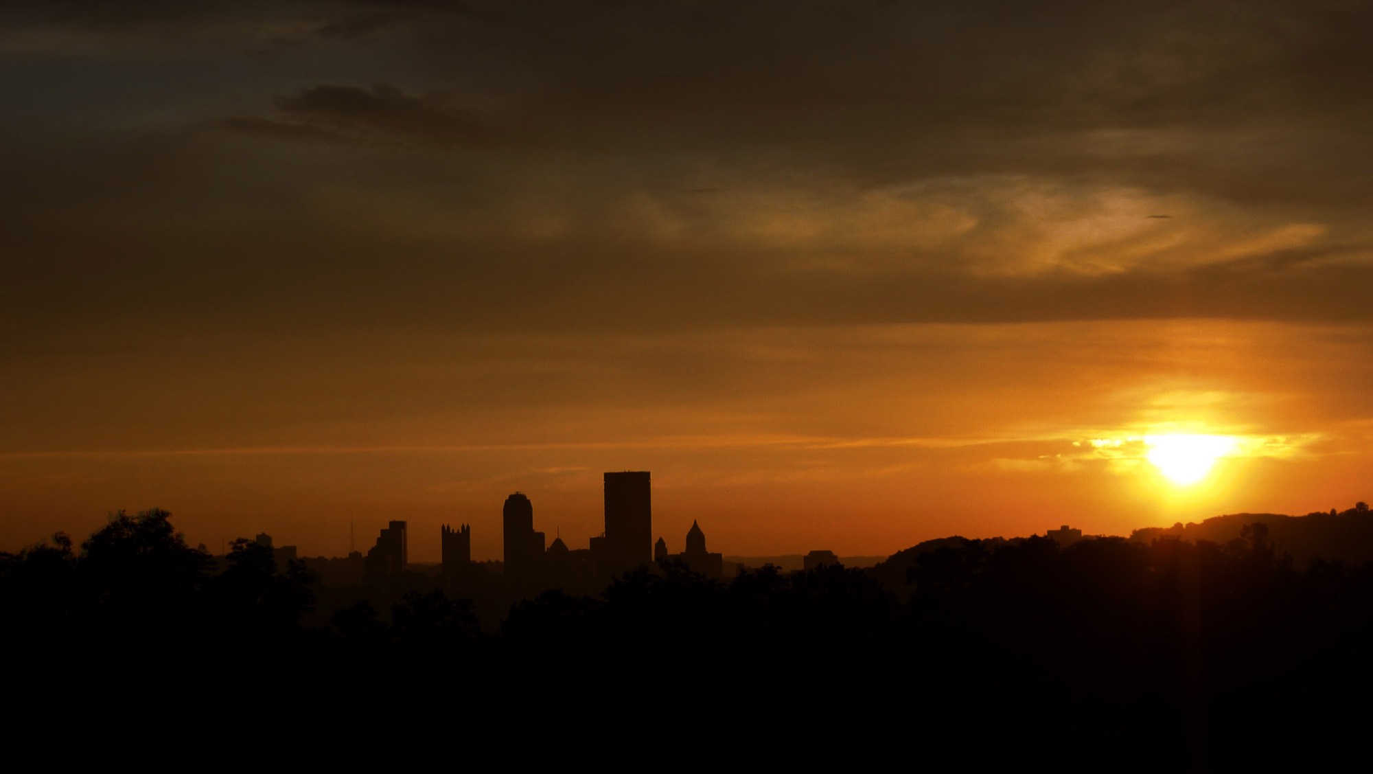 The Pittsburgh skyline in silhouette at golden sunset
